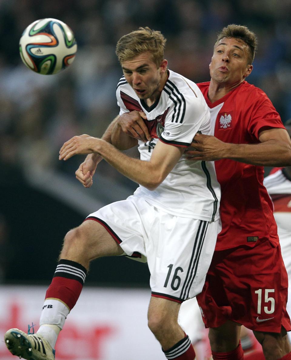 Germany's Christoph Kramer, left, and Poland's Thiago Cionek, right, challenge for the ball during a friendly soccer match between Germany and Poland in Hamburg, Germany, Tuesday, May 13, 2014. (AP Photo/Michael Sohn)