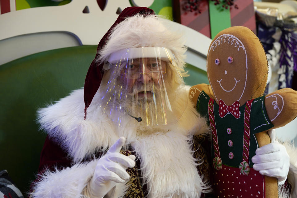 Santa Claus wears a face mask covering while waiting for children to visit in Park Meadows Mall Tuesday, Dec. 8, 2020, in Lone Tree, Colo. (AP Photo/David Zalubowski)