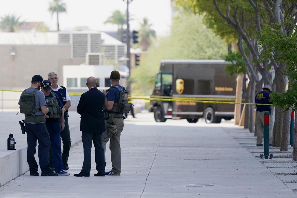 Federal law enforcement personnel stand outside the Sandra Day O'Connor Federal Courthouse Tuesday, Sept. 15, 2020, in Phoenix. A drive-by shooting wounded a federal court security officer Tuesday outside the courthouse in downtown Phoenix, authorities said. The officer was taken to a hospital and is expected to recover, according to city police and the FBI, which is investigating. (AP Photo/Ross D. Franklin)