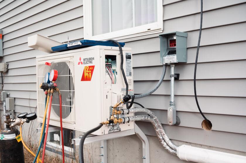 WINDHAM, ME - JANUARY 19: An electric heat pump, freshly installed by a crew from ReVision Energy, a New England company specializing in solar energy and electric heat pump installations, sits mounted to the side of a home in Windham, Maine on Thursday, January 19, 2023. Improved energy efficiency with heat pump technology and new tax incentives have contributed to the popularity of heat pumps in New England, as many homeowners are facing increased costs of heating their homes with oil, propane and other fossil fuels. (Photo by Tristan Spinski for The Washington Post via Getty Images)