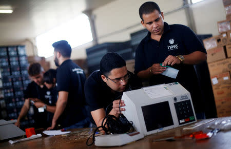 Brazilian electoral workers seal electronic ballot boxes in Brasilia, Brazil September 19, 2018. REUTERS/Adriano Machado