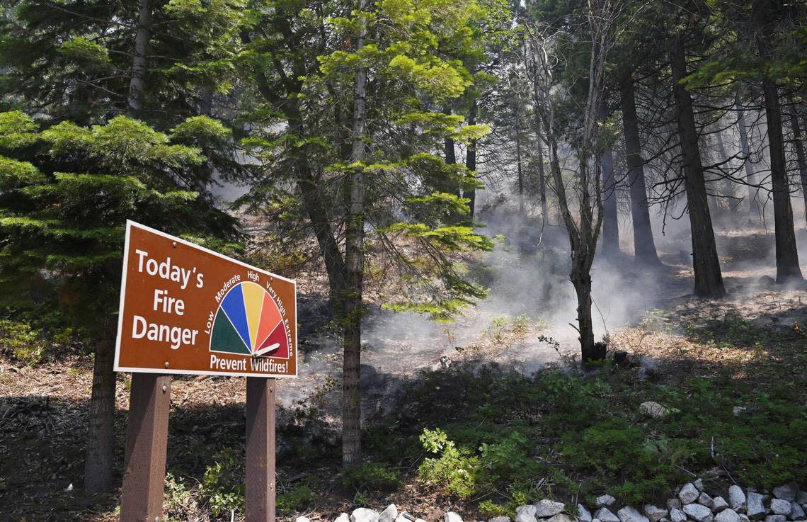 A sign warns of the danger along Wawona Road just north of the South Gate entrance as the Washburn Fire burns in Yosemite National Park Monday, July 11, 2022.