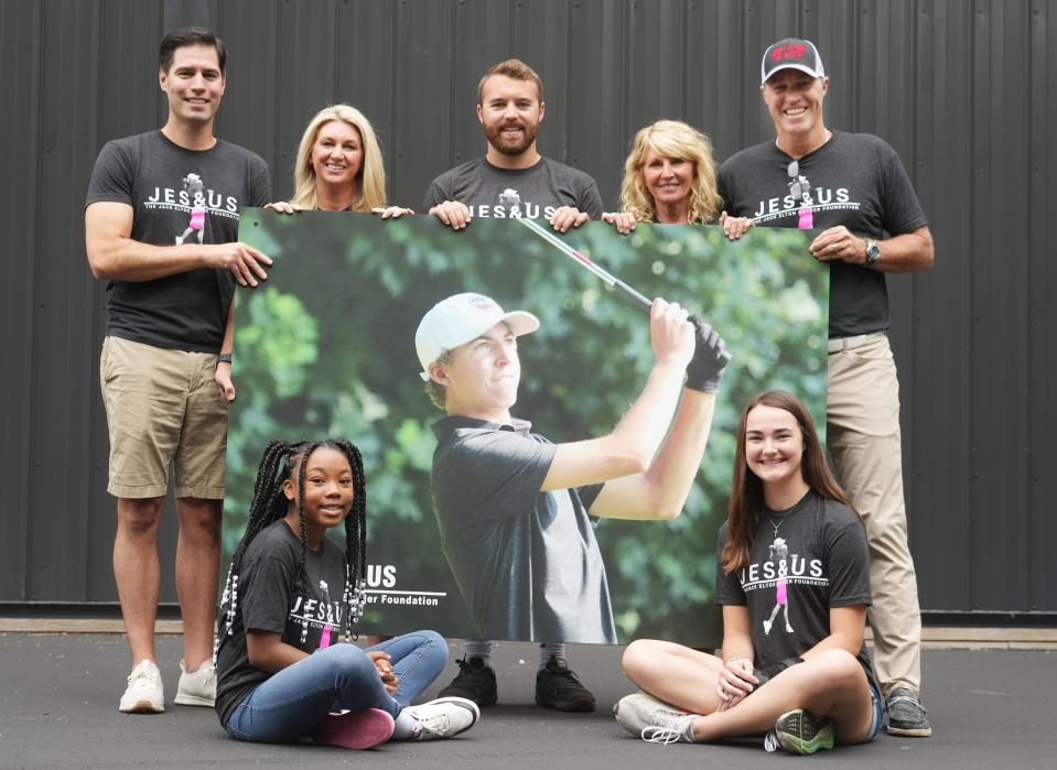 The parents of Jack Snyder, a golfer at Olentangy Liberty who died in 2021, started a foundation to help young golfers. Gathering around a picture of Jack are two of the scholarship recipients, Bella Mitchell (seated, left) and Maddie Digel (seated right), 15. Holding the sign is (from left) Ian Biever, Jack's sister Kirstin Biever, older brother Chase Snyder, and parents Jacci and Sean Snyder.