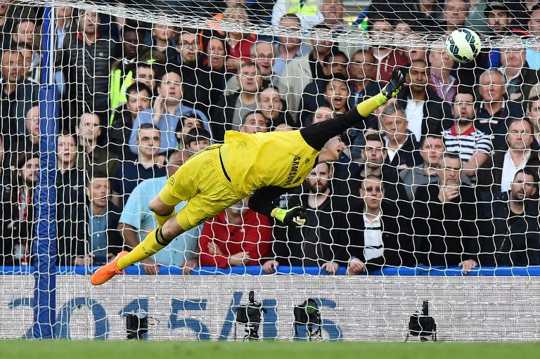 Chelsea's Belgian goalkeeper Thibaut Courtois dives reaching for the ball from a shot from Manchester United's Colombian striker Radamel Falcao that flashes wide during their English Premier League football match in London on April 18, 2015