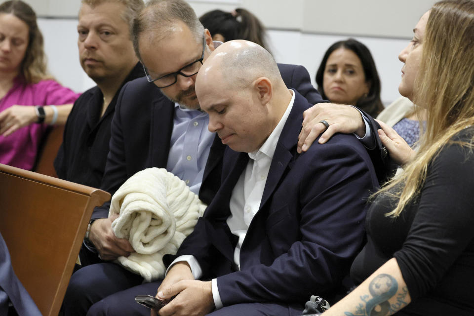 Ryan Petty comforts Ilan Alhadeff as they await the decision in the trial of Marjory Stoneman Douglas High School shooter Nikolas Cruz at the Broward County Courthouse on October 13, 2022, in Fort Lauderdale, Florida. / Credit: Amy Beth Bennett / Getty Images