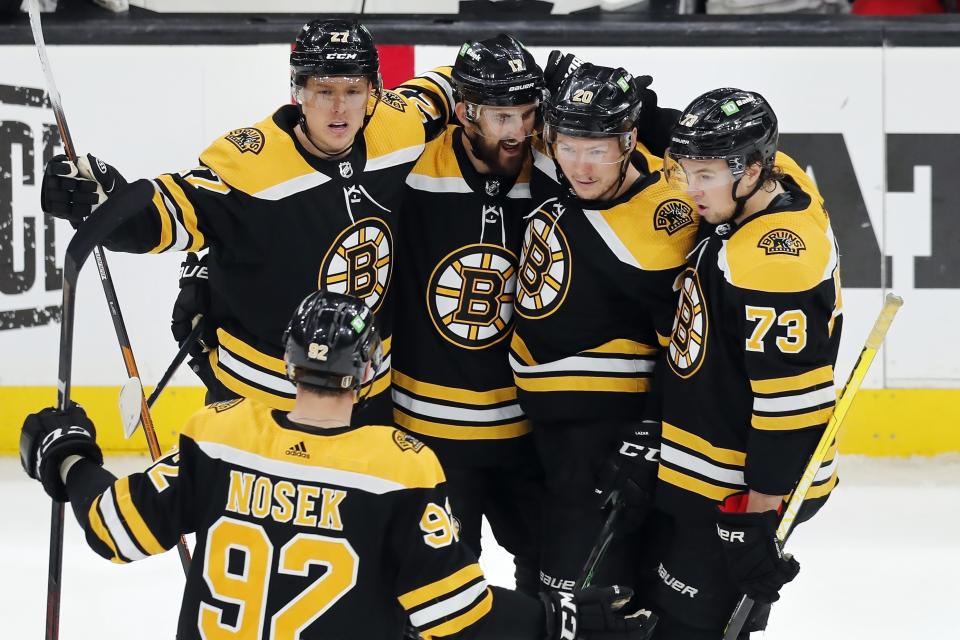 Boston Bruins' Curtis Lazar (20) celebrates his goal against the Carolina Hurricanes with Tomas Nosek (92), Hampus Lindholm (27), Nick Foligno (17) and Charlie McAvoy (73) during the third period in Game 6 of an NHL hockey Stanley Cup first-round playoff series Thursday, May 12, 2022, in Boston. (AP Photo/Michael Dwyer)