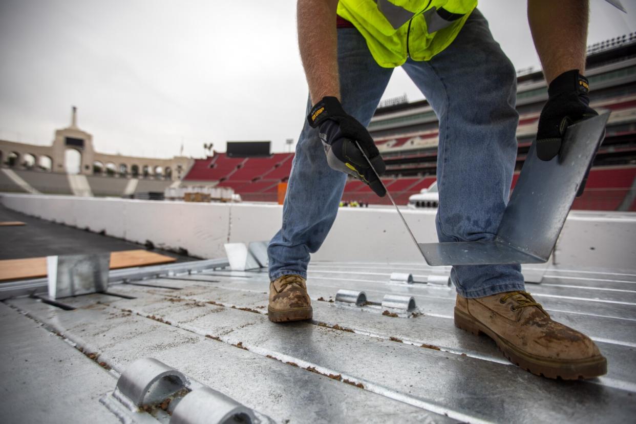 Terence Pannell works to install the SAFER barrier around the race track at the Coliseum.