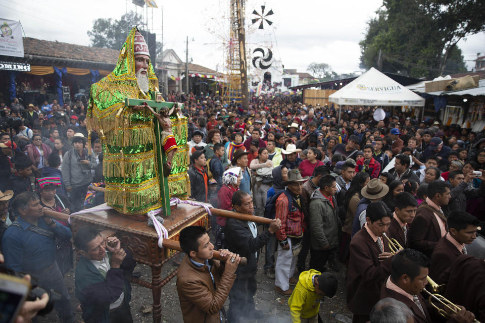 Personas cargan una estatua en honor a Santo Tomás Apóstol durante una procesión en la principal jornada de fiesta en honor al santo patrono de Chichicastenango, en Guatemala, el sábado 21 de diciembre de 2019. (AP Foto/Moisés Castillo)