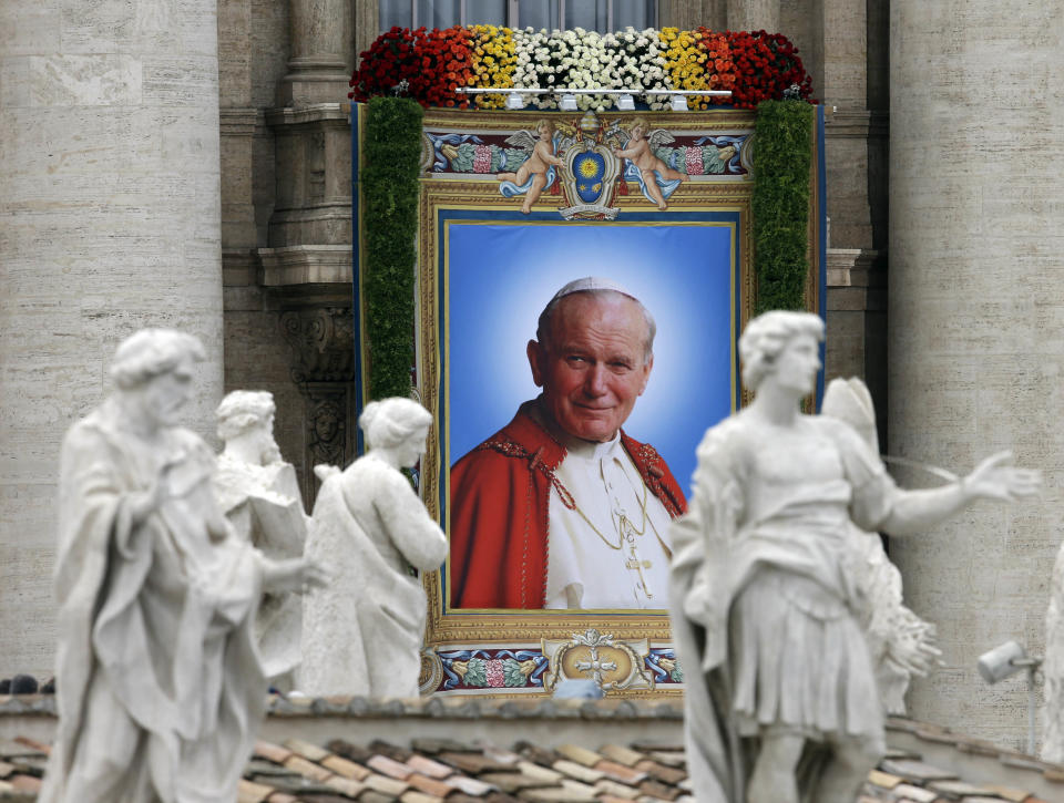 The tapestry showing Pope John Paul II hangs from the facade of St. Peter's Basilica during a solemn celebration led by Pope Francis I where two Popes, John Paul II and John XXIII, were canonized, in St. Peter's Square at the Vatican, Sunday, April 27, 2014. (AP Photo/Alessandra Tarantino)