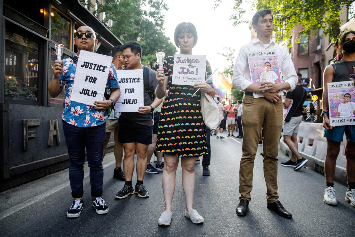 People hold signs for a vigil commemorating Julio Ramirez (Julius Constantine Motal / NBC News)