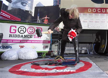 Jody Watkins smashes old computers as part of "Good Riddance Day" in Times Square in New York, December 28, 2013. REUTERS/Carlo Allegri