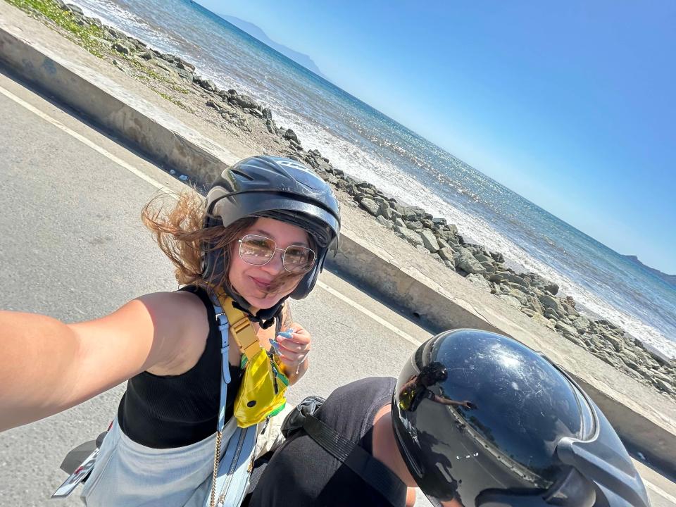 Woman on a scooter by the sea