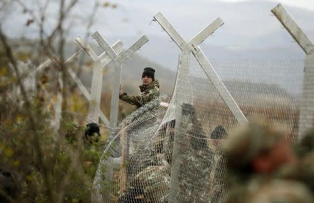 Macedonian soldiers erect a metal fence on the border with Greece, near Gevgelija, Macedonia, November 28, 2015. REUTERS/Stoyan Nenov