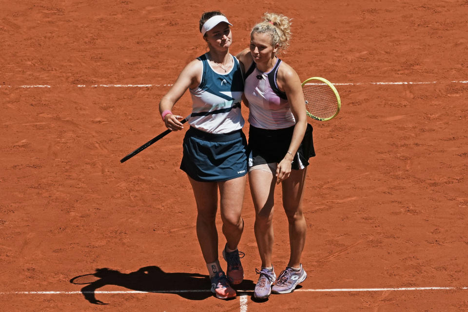 Czech Republic's Barbora Krejcikova, left, and compatriot Katerina Siniakova walk together after defeating USA's Bethanie Mattek-Sands and Poland's Iga Swiatek during their women's doubles final match of the French Open tennis tournament at the Roland Garros stadium Sunday, June 13, 2021 in Paris. (AP Photo/Thibault Camus)