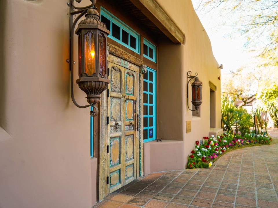 An adobe building on the left and a garden path on the right at Hermosa Inn