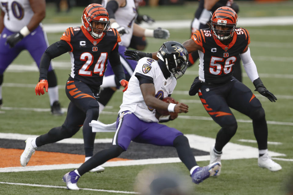 Baltimore Ravens quarterback Lamar Jackson (8) scrambles away from Cincinnati Bengals strong safety Vonn Bell (24) and middle linebacker Josh Bynes (56) during the first half the Cincinnati Bengals during the first half of an NFL football game, Sunday, Jan. 3, 2021, in Cincinnati. (AP Photo/Aaron Doster)