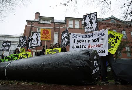 Climate advocates and representatives from the Rosebud Sioux Tribe in South Dakota protest against the Keystone XL pipeline in front of U.S. Senator Mary Landrieu's home (D-LA), the chair of the Senate Energy Committee, in Washington November 17, 2014. REUTERS/Gary Cameron