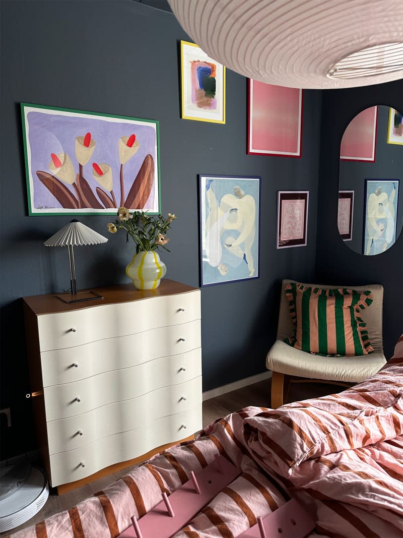 Colorful art prints decorate the bedroom walls.