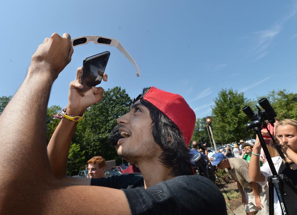 Swaraj Patel, 18, takes a photo of the eclipse on his smartphone through a pair of solar glasses Aug. 21 at an eclipse-viewing party held at Penn State Behrend in Harborcreek Township. Patel is a sophomore computer engineering student from India. Hundreds turned out for the event at Behrend, which featured telescopes fitted with solar filters available for viewing the partial eclipse. [CHRISTOPHER MILLETTE/ERIE TIMES-NEWS]