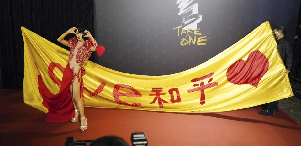 Chinese-American actress Bai Ling poses with her slogan "Love, Peace" at the 57th Golden Horse Awards in Taipei, Taiwan, Saturday, Nov. 21, 2020. Bai is nominated for Best Leading Actress for the film "The Abortionist" at this year's Golden Horse Awards -one of the Chinese-language film industry's biggest annual events. (AP Photo/Billy Dai)