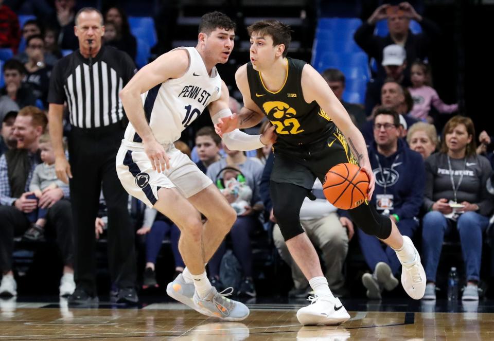 Iowa forward Patrick McCaffery (22) dribbles the ball around Penn State guard Andrew Funk (10) during the first half of an NCAA college basketball game, Sunday, Jan. 1, 2023, at Bryce Jordan Center in State College, Pa.