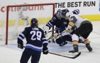 May 20, 2018; Winnipeg, Manitoba, CAN; Vegas Golden Knights right wing Alex Tuch (89) tries to get to the puck against Winnipeg Jets goaltender Connor Hellebuyck (37) and defenseman Dmitry Kulikov (5) in the second period in game five of the Western Conference Final of the 2018 Stanley Cup Playoffs at Bell MTS Centre. Mandatory Credit: James Carey Lauder-USA TODAY Sports