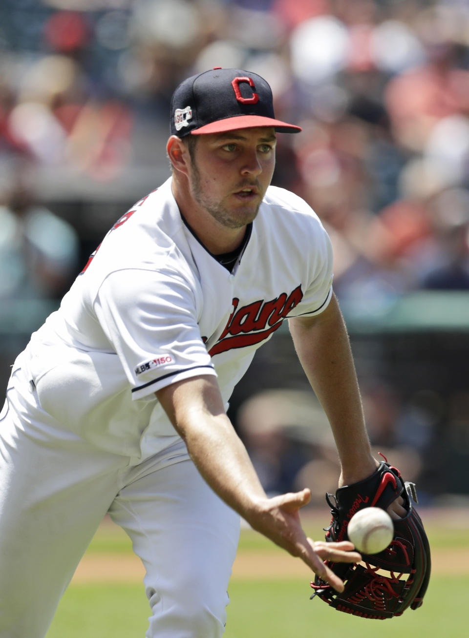 Cleveland Indians starting pitcher Trevor Bauer tosses the ball to first base to get Kansas City Royals' Whit Merrifield out in the fifth inning in a baseball game, Wednesday, June 26, 2019, in Cleveland. (AP Photo/Tony Dejak)
