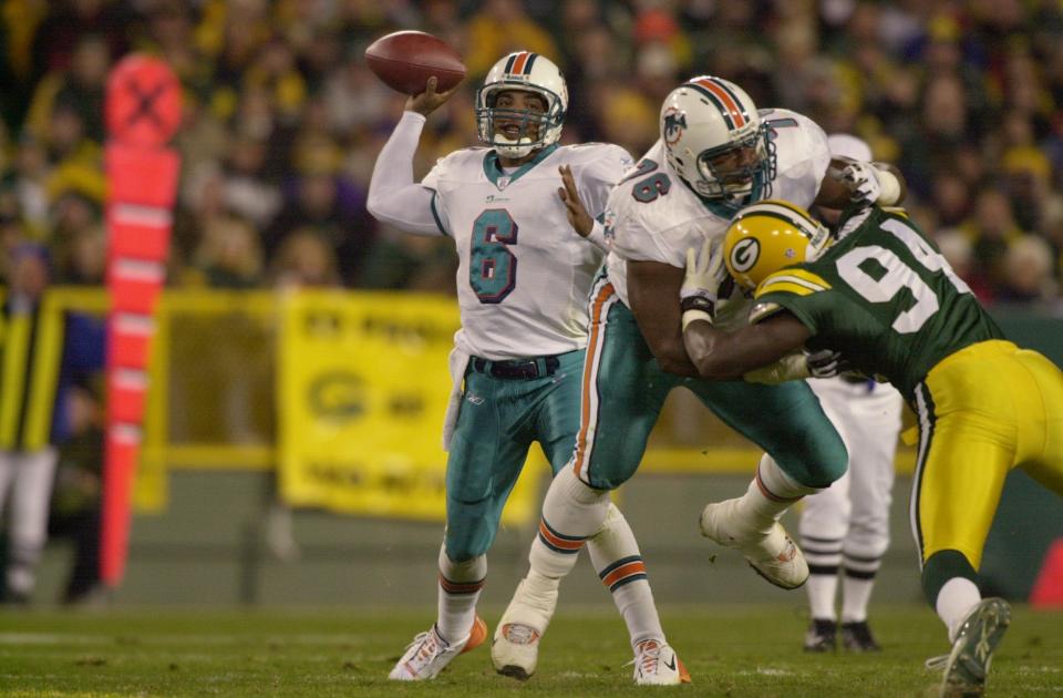 GREEN BAY, WI - NOVEMBER 4:  Quarterback Ray Lucas #6 of the Miami Dolphins passes downfield as tackle Marcus Spriggs #76 blocks defensive end Kabeer Gbaja-Biamila #94 of the Green Bay Packers during their game on November 4, 2002 at Lambeau Field in Green Bay, Wisconsin.  (Photo by Jonathan Daniel/Getty Images)