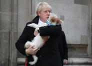 FILE - Britain's Prime Minister and Conservative Party leader Boris Johnson holds his dog Dilyn as he leaves after voting in the general election at Methodist Central Hall, Westminster, London, Thursday, Dec. 12, 2019. British media say Prime Minister Boris Johnson has agreed to resign on Thursday, July 7 2022, ending an unprecedented political crisis over his future. (AP Photo/Frank Augstein, File)