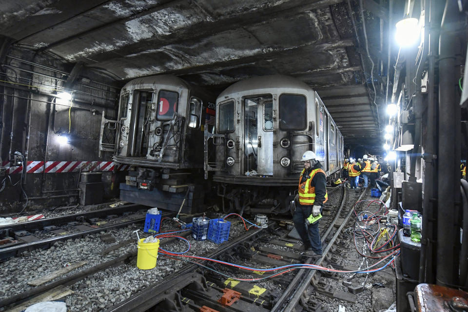 In the cramped confines of a New York City subway tunnel, work crews labor to lift hulking rail cars back onto the tracks after two passenger trains collided and derailed Thursday, causing service disruptions that stretched into a second day, Friday, Jan. 5, 2024. Getting the last of the train's 10 cars onto the rails is a complicated operation because of the subway tunnel's low ceiling, said NYC Transit President Richard Davey. (Marc A. Hermann/Metropolitan Transportation Authority via AP)