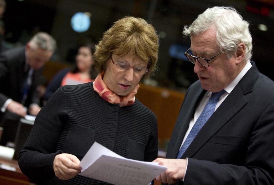 Executive Secretary General of the EU External Action Service Pierre Vimont, right, shows a paper to EU Foreign Policy chief Catherine Ashton during an emergency meeting of EU foreign ministers at the EU Council building in Brussels on Monday, March 3, 2014. EU foreign ministers meet in emergency session on Monday to discuss the ongoing crisis in Ukraine. (AP Photo/Virginia Mayo)