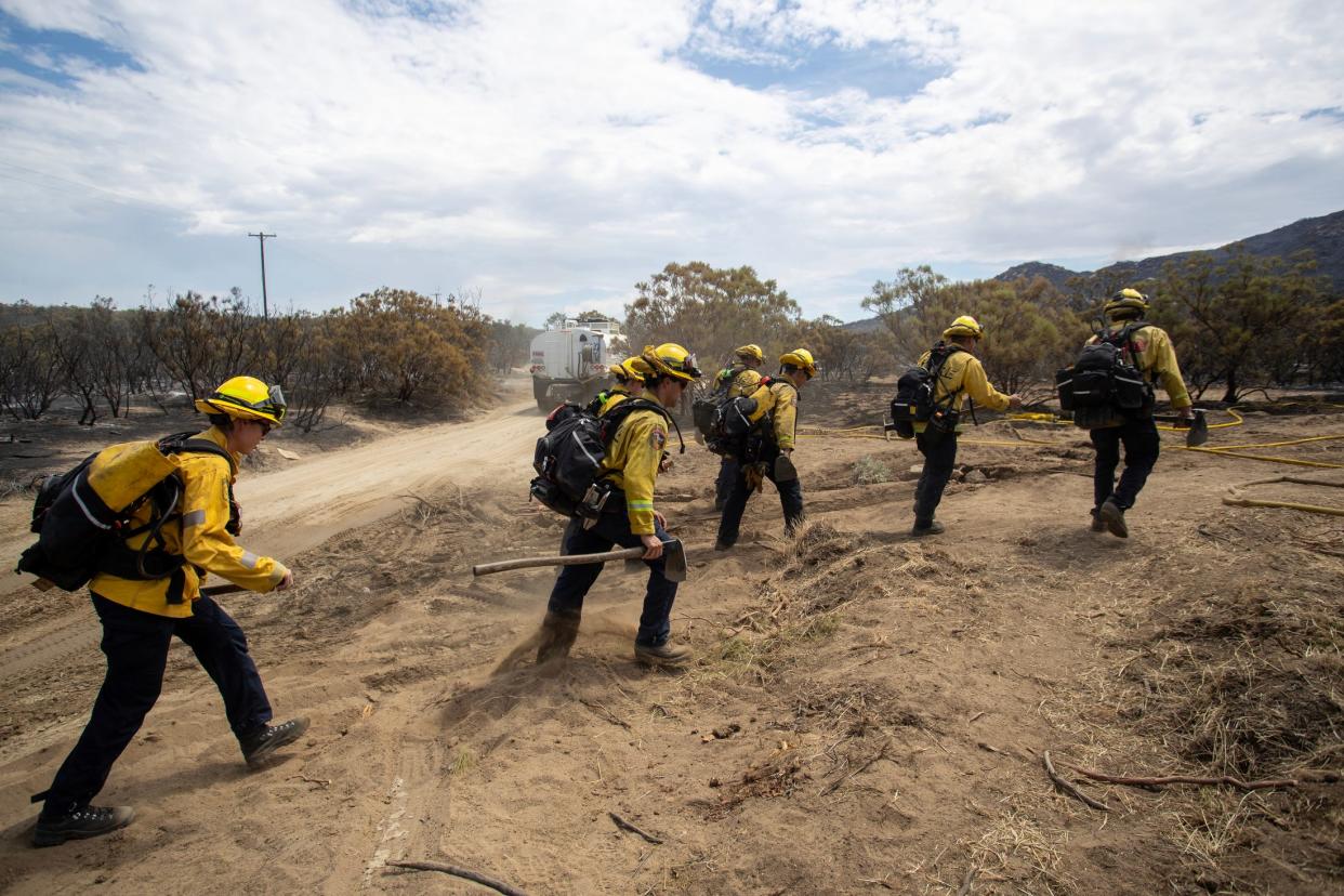 Cal Fire firefighters hike to knock out hot spots on the Bonny Fire near Anza, Calif., on Saturday, July 29, 2023.