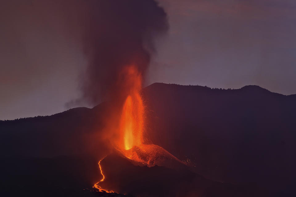 Lava flows from a volcano on the Canary island of La Palma, Spain in the early hours of Sunday Sept. 26, 2021. A volcano in Spain's Canary Islands is keeping nerves on edge several days since it erupted, producing loud explosions, a huge ash cloud and cracking open a new fissure that spewed out more fiery molten rock. (AP Photo/Daniel Roca)