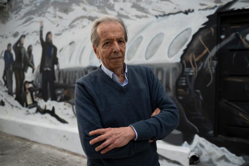 Daniel Fernandez, one of the sixteen Uruguayan survivors of the airplane crash of Uruguayan Air Force Flight 571, which crashed in the Andes mountains on October 13, 1972, poses in front of a mural made by Graff Express depicting the accident in Montevideo on November 15, 2023.