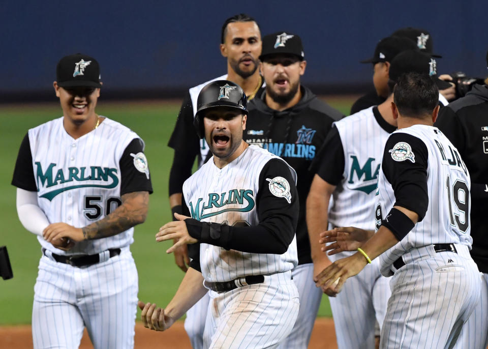 Jul 26, 2019; Miami, FL, USA; Miami Marlins third baseman Neil Walker (18) celebrates with teammates after scoring the winning run on a sacrifice fly by Marlins left fielder Harold Ramirez (not pictured) against the Arizona Diamondbacks at Marlins Park. Mandatory Credit: Steve Mitchell-USA TODAY Sports