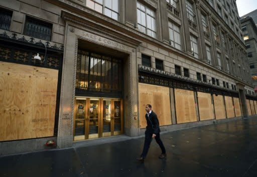 A man walks past a boarded-up Saks Fifth Avenue as New Yorkers prepare for Hurricane Sandy. Hurricane Sandy drove a deadly tidal surge into coastal cities along the eastern US coast Monday and pushed storm-force winds, torrential rain and heavy snow deep inland