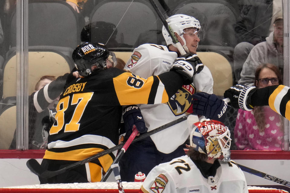 Pittsburgh Penguins' Sidney Crosby (87) checks Florida Panthers' Niko Mikkola (77) during the third period of an NHL hockey game in Pittsburgh, Wednesday, Feb. 14, 2024. The Panthers won 5-2. (AP Photo/Gene J. Puskar)