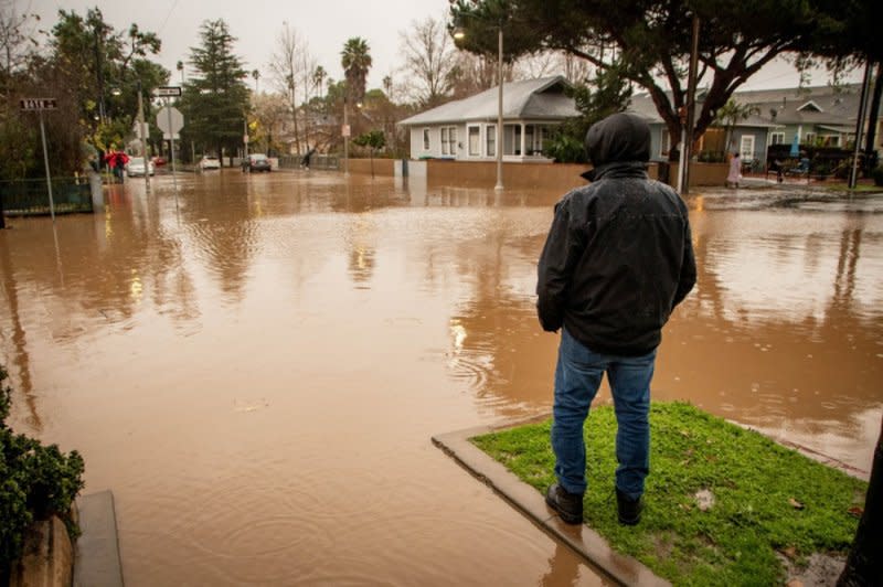 A man looks at the flooded intersection of Bath and Hailey streets during an atmospheric river weather event in Santa Barbara on February 4. The storm triggered flood watches for nearly 40 million people in California. Photo by Erick Madrid/EPA