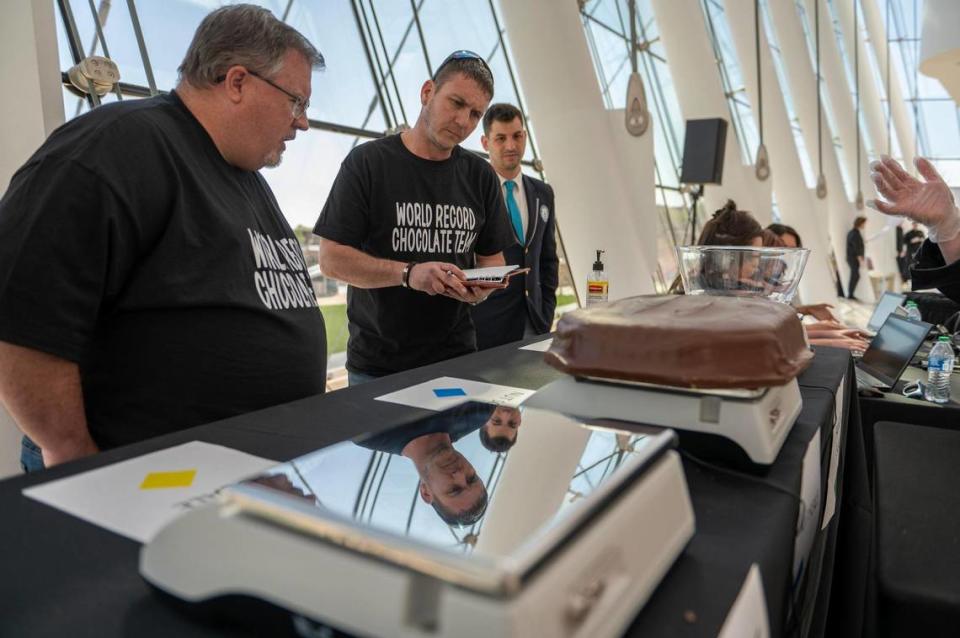 Russ Bishop, center, member of Russell Stover’s world record chocolate team, weighs in giant slabs of chocolate during Monday’s attempt to break the Guinness World Record for the largest box of chocolate.