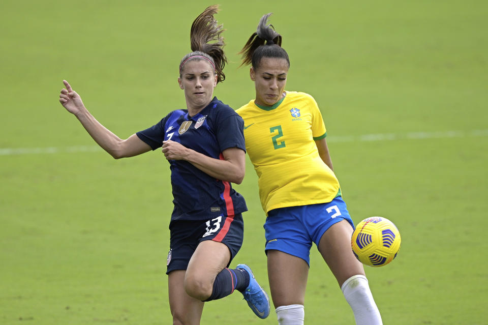 United States forward Alex Morgan (13) and Brazil defender Kathellen (2) compete for a ball during the first half of a SheBelieves Cup women's soccer match, Sunday, Feb. 21, 2021, in Orlando, Fla. (AP Photo/Phelan M. Ebenhack)