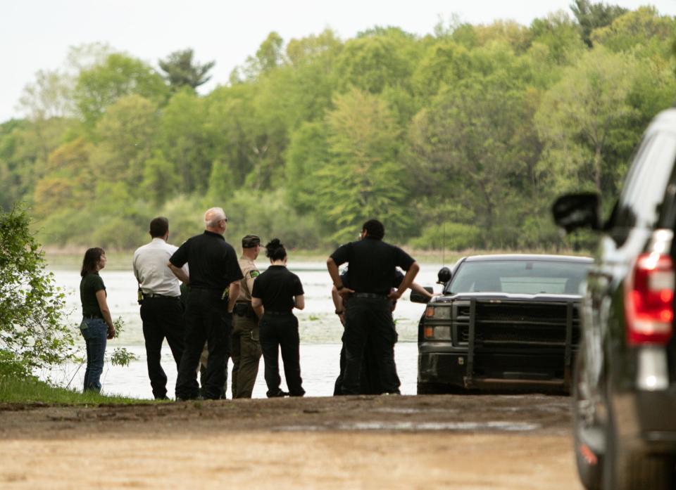 Hamburg police and fire personnel, Livingston County Sheriff's deputies, Michigan DNR staff and Livingston County EMS watch the rescue of a man in distress on Chilson Pond in Hamburg Township Saturday, May 21, 2022.