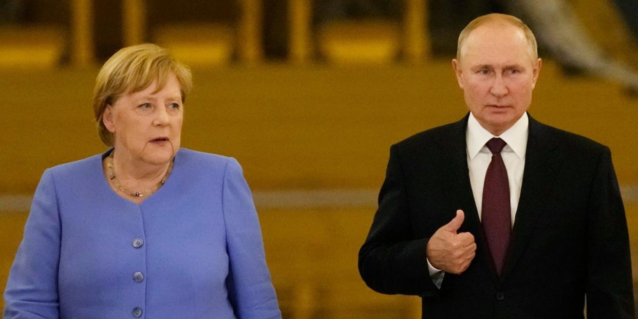 Russian President Vladimir Putin, right, and German Chancellor Angela Merkel enter the hall for a joint news conference following their talks in the Kremlin in Moscow, Russia, Friday, Aug. 20, 2021.