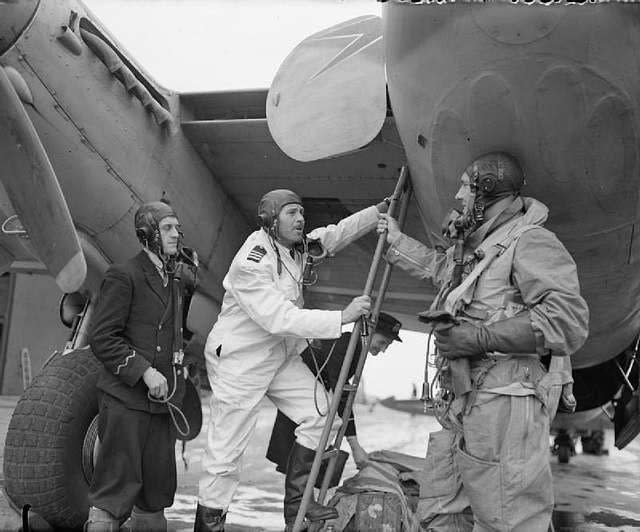 A BOAC Mosquito pilot climbing aboard an FB.VI. Note the four sealed 20mm cannon gun ports in the nose. <em>Crown Copyright</em>