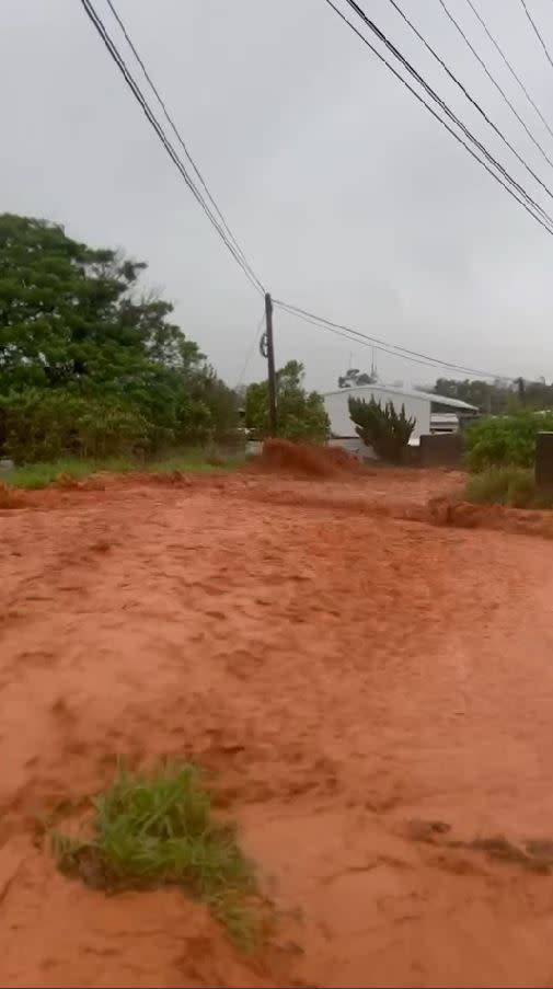 住家前馬路變成了湍急紅河，民眾看到這一幕嚇傻趕緊拿起手機紀錄。(圖／翻攝畫面)