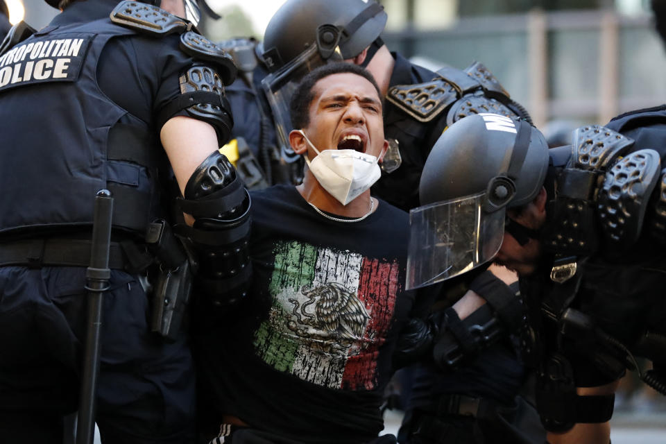 A demonstrator is taken into custody by police after a curfew took effect during a protest over the death of George Floyd, Monday, June 1, 2020, near the White House in Washington. Floyd died after being restrained by Minneapolis police officers. (AP Photo/Alex Brandon)