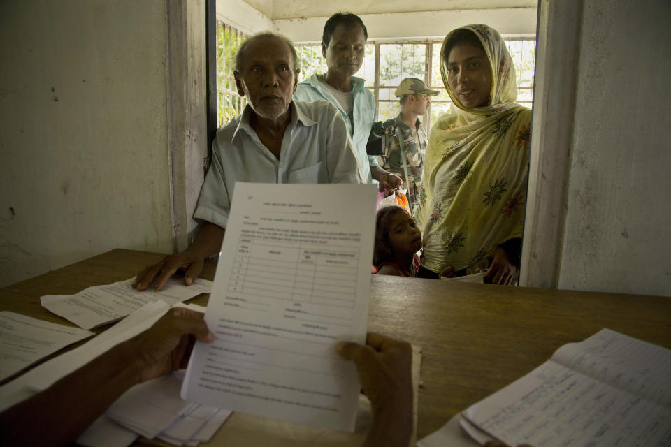 People whose names were left out in the National Register of Citizens (NRC) draft stand to collect forms to file appeals in Mayong, 45 kilometers (28 miles) east of Gauhati, India, Friday, Aug. 10, 2018. A draft list of citizens in Assam, released in July, put nearly 4 million people on edge to prove their Indian nationality. (AP Photo/Anupam Nath)