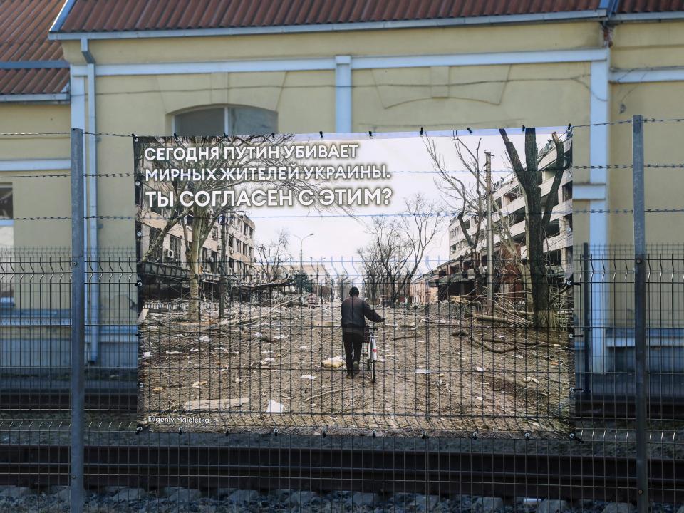 A banner with a photo by Evgeniy Maloletka, a photographer working for Associated Press (AP), is seen next to other photographs of Russia's war in Ukraine at the railway station in Vilnius, Lithuania on March 25, 2022, where transit trains from Moscow to Kaliningrad make a stop over.