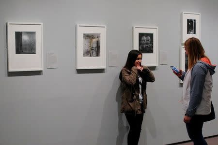 A visitor poses for a photograph at the exhibit "Imogen Cunningham: In Focus" at the Museum of Fine Arts, Boston, in Boston, Massachusetts, U.S., April 26, 2017. REUTERS/Brian Snyder