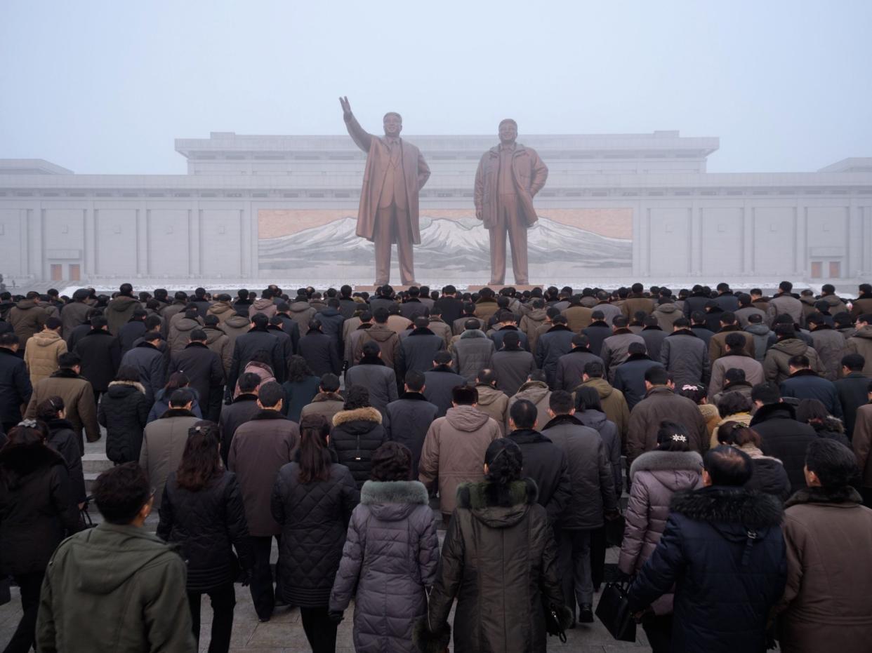 Pyongyang residents prepare to bow before statues of Kim Il Sung and Kim Jong Il during National Memorial Day on Sunday: AFP/Getty Images