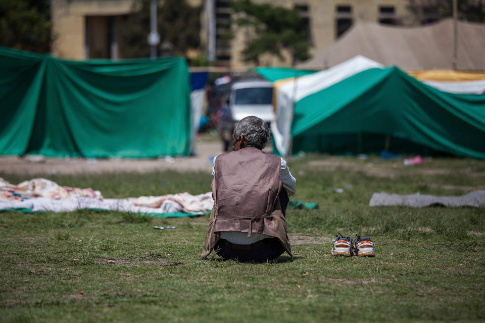 A resident sits on the ground in an evacuation area set up by the authorities in Tundhikel park on April 27, 2015 in Kathmandu, Nepal.   (Photo by Omar Havana/Getty Images)